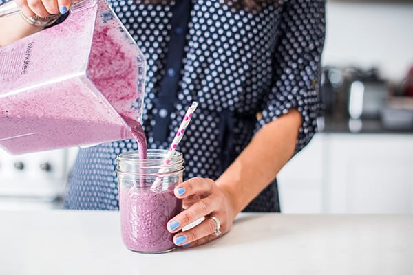 pouring smoothie into a glass
