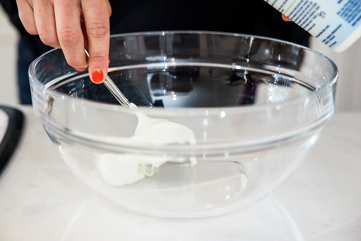 adding plain yogurt to an empty bowl