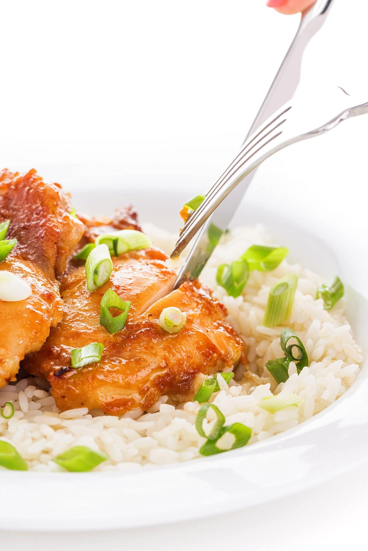 Cutting into teriyaki chicken thighs