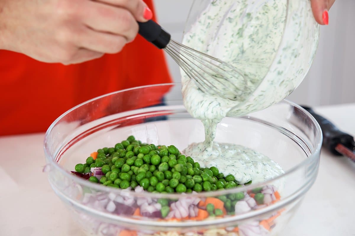 Adding dill dressing to the orzo salad