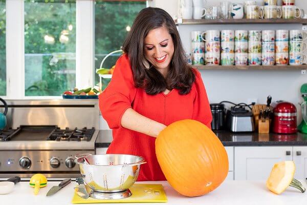 Liz cleaning out pumpkin seeds into a colander.