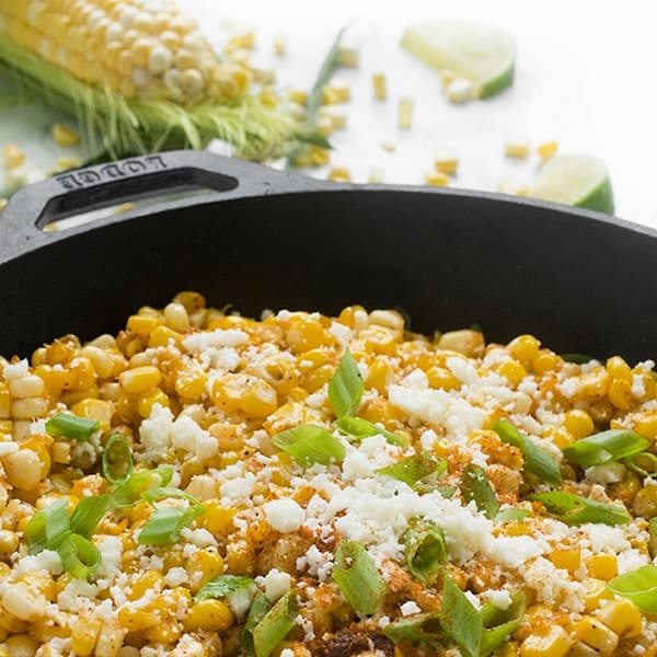 corn in a skillet with green onions
