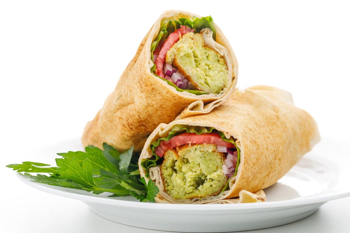Authentic Lebanese falafel wrap on a plate with fresh greens.