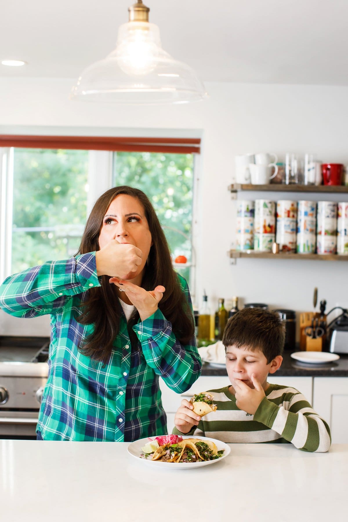 Woman and son eating beef birria tacos