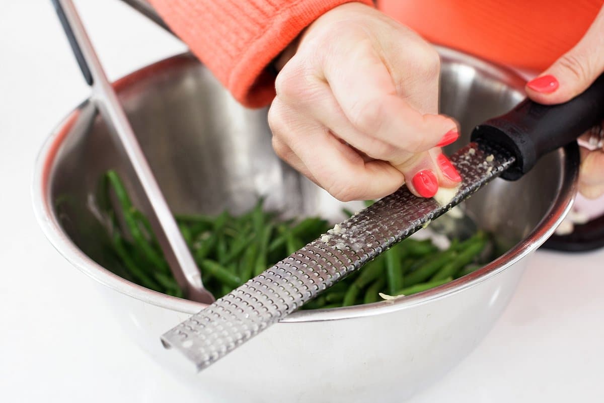 grating garlic over the green beans