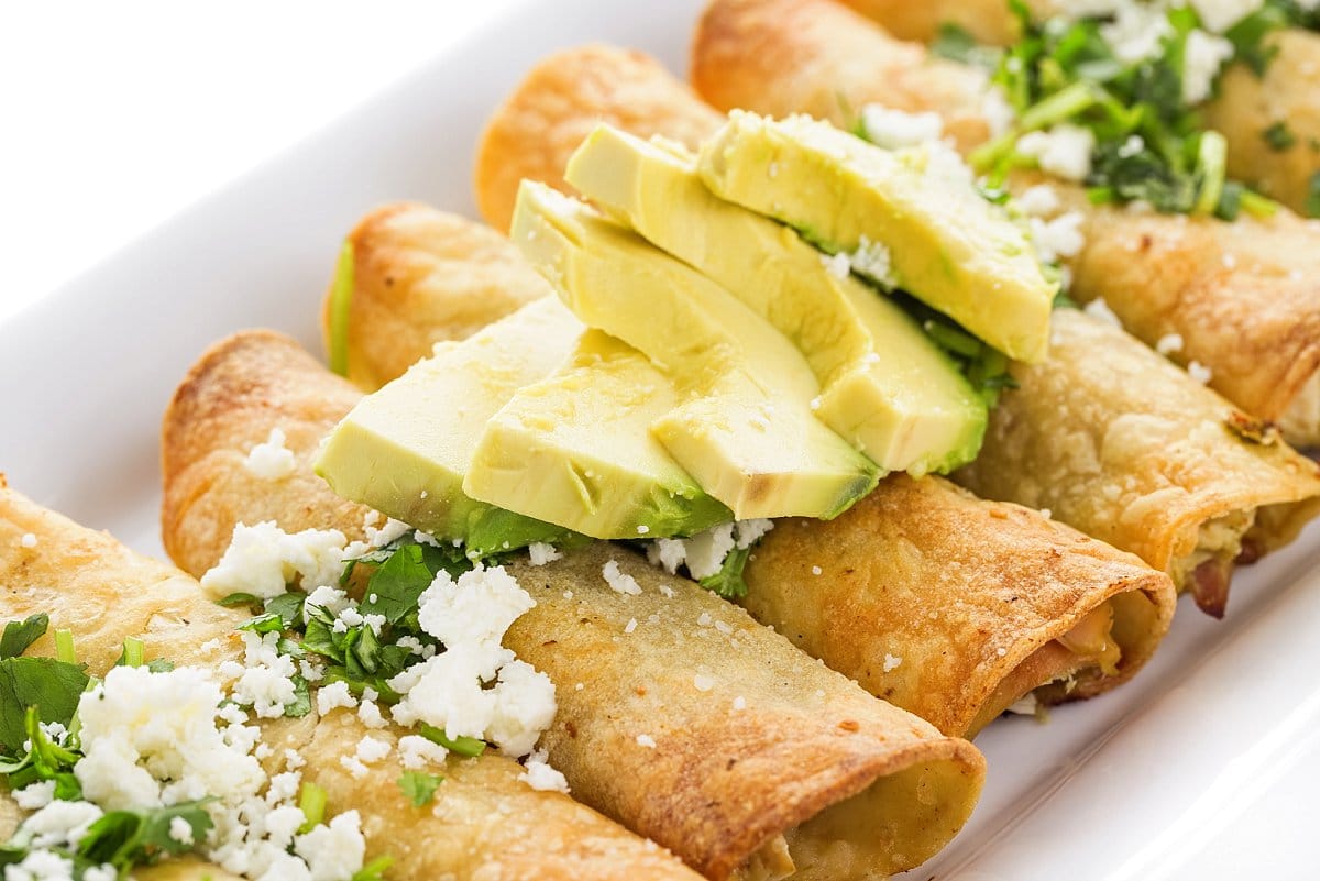chicken taquitos with avocado and cojita cheese