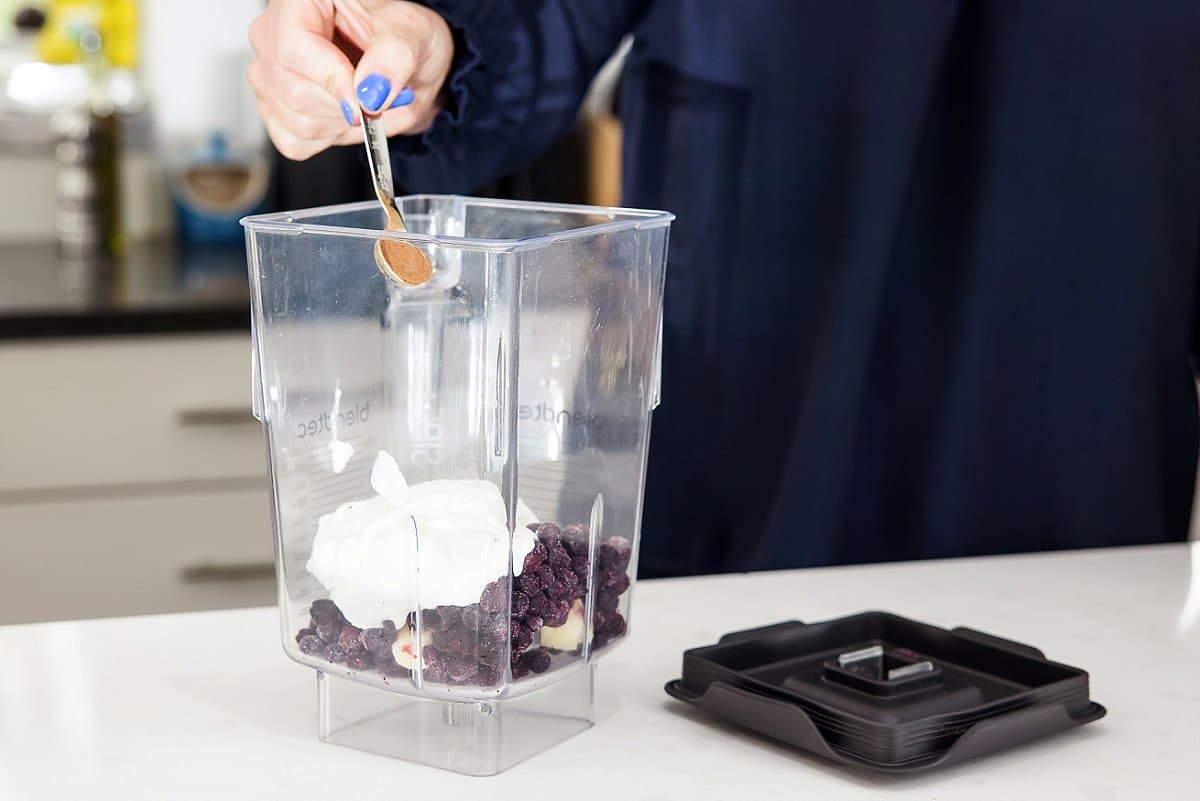 adding cinnamon into a blender