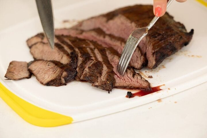Garlic Soy Marinated Flank Steak being cut