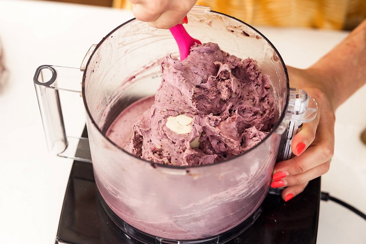 scraping vegan blueberry nice cream out of a food processor