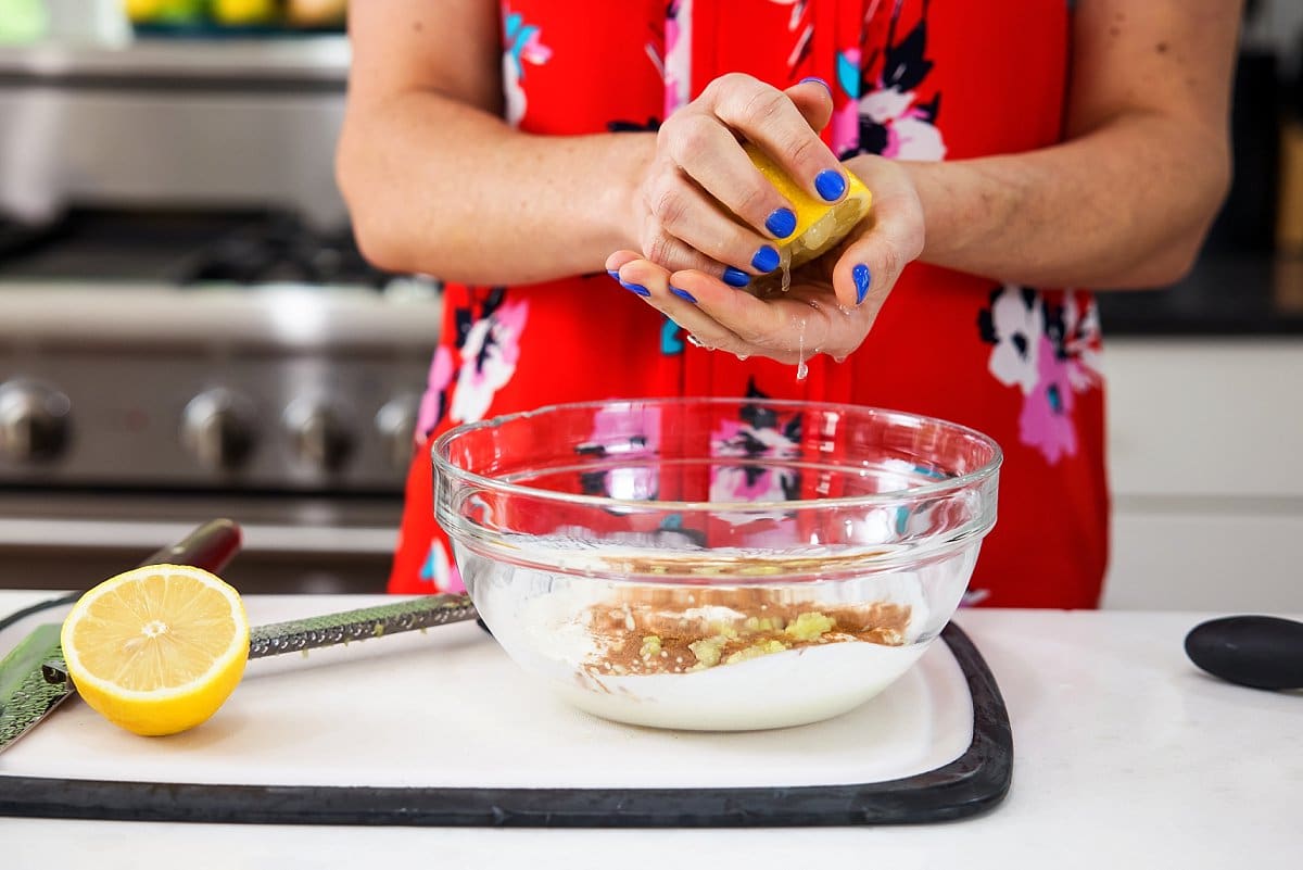 adding lemon juice to marinade in a bowl