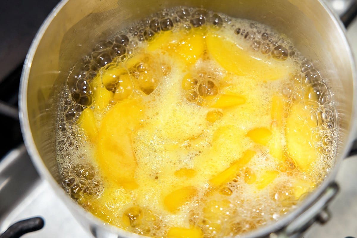 Peaches boiling in saucepan.