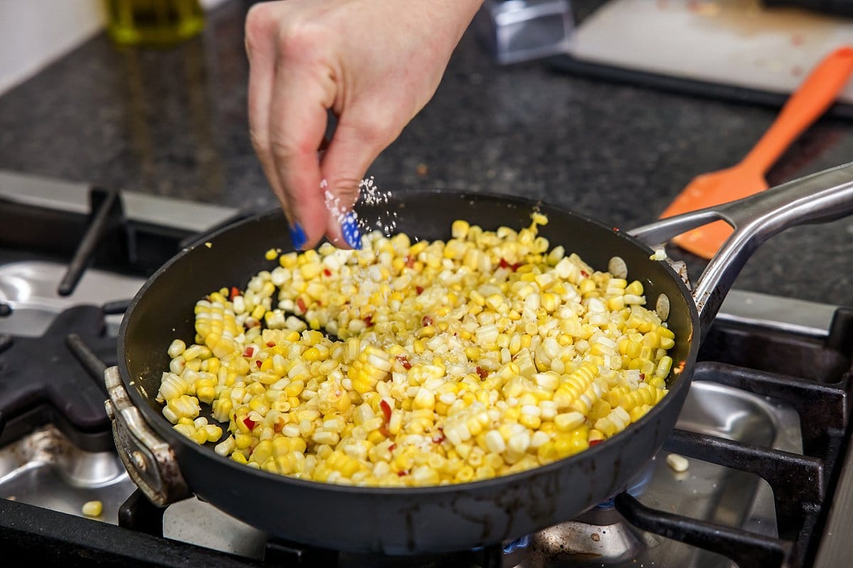 sprinkling salt on corn skillet