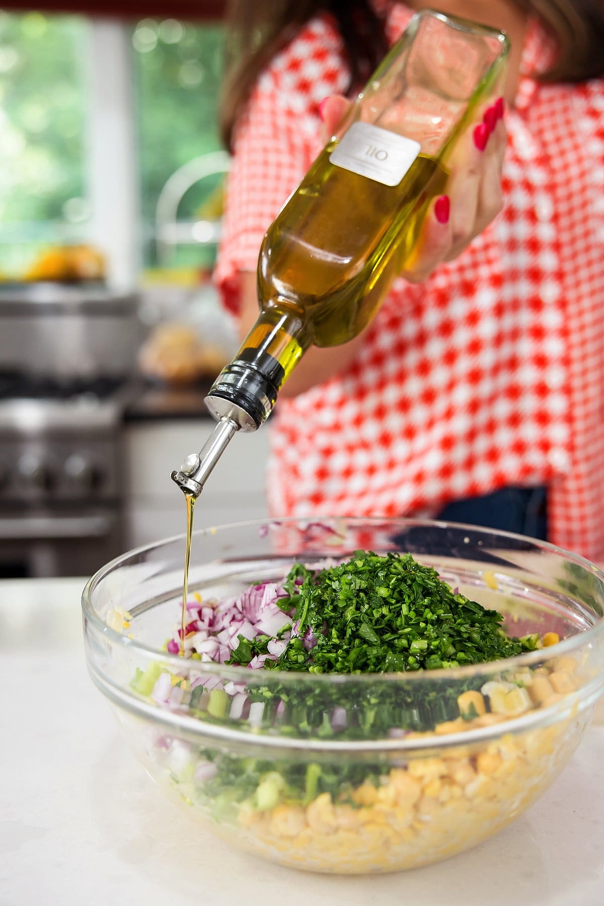 Adding olive oil to salad