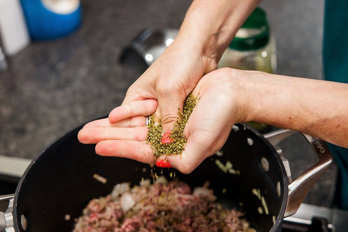 adding oregano for stuffed pepper soup