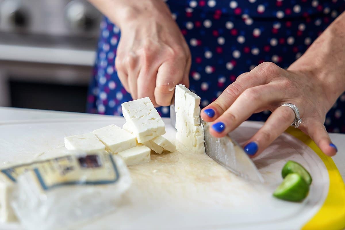 feta cheese being cut for tomato salad