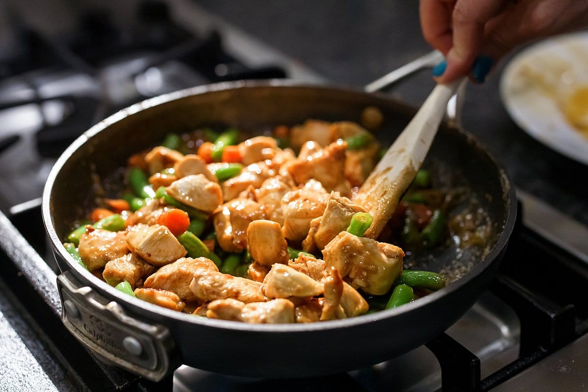 Sesame chicken and green bean stir fry in pan.