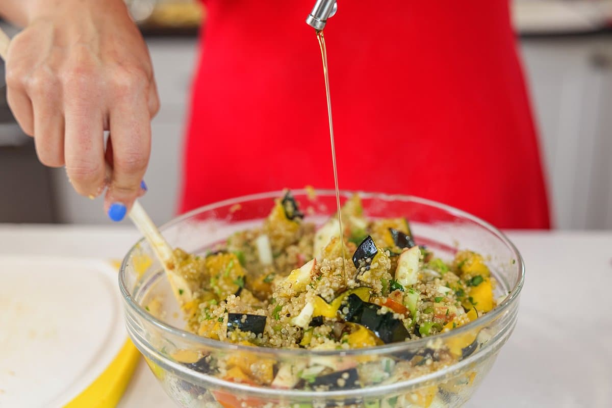 Liz dressing quinoa salad with acorn squash and apples.