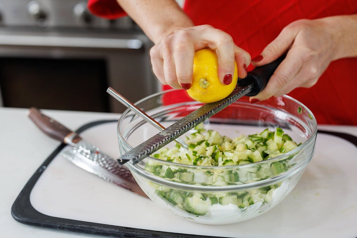 Using a microplane to freshly zest a lemon.