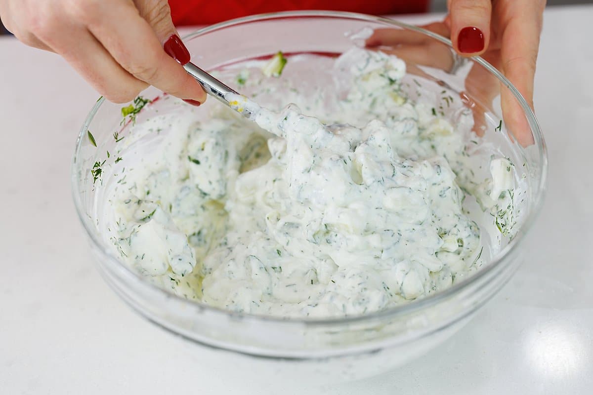 Stirring together Greek tzatziki sauce.