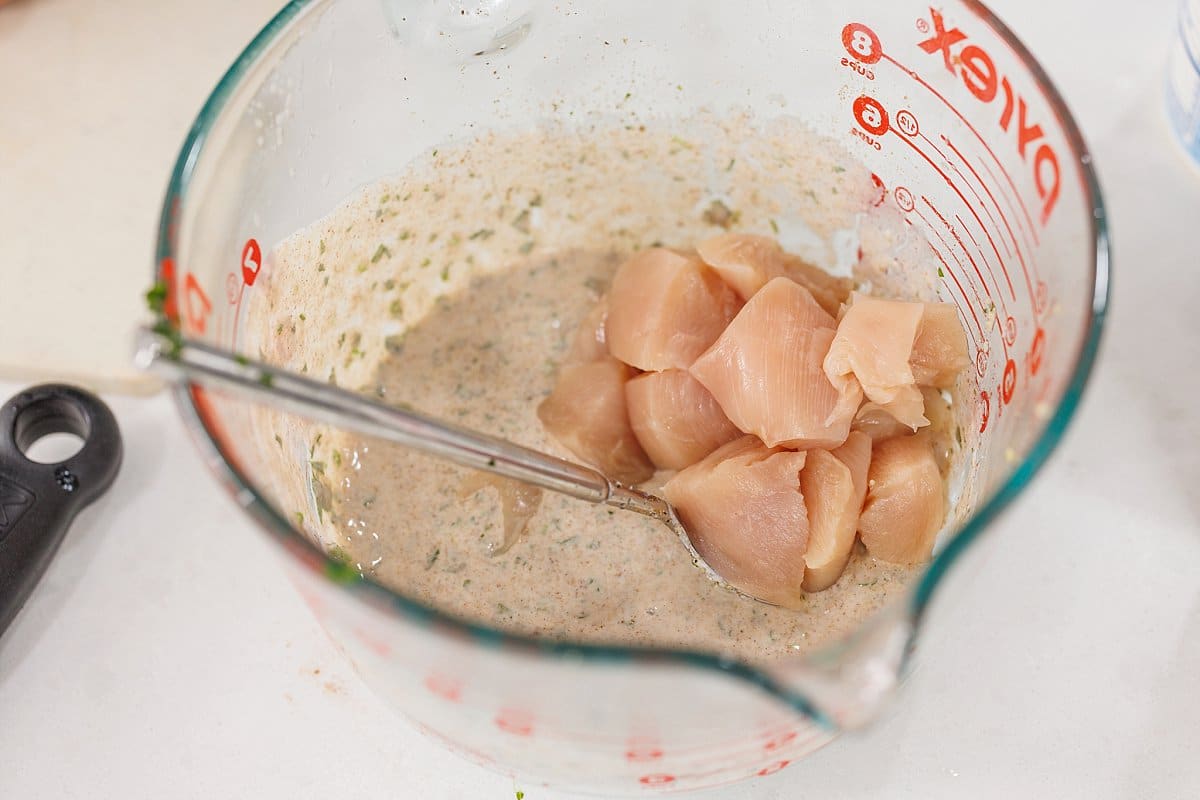 Raw chicken cubes added to marinade.