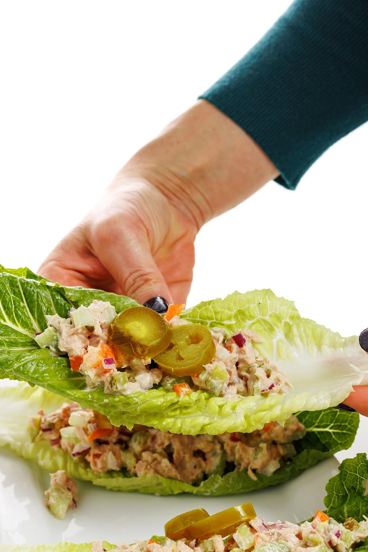 Holding a healthy tuna salad lettuce cup.