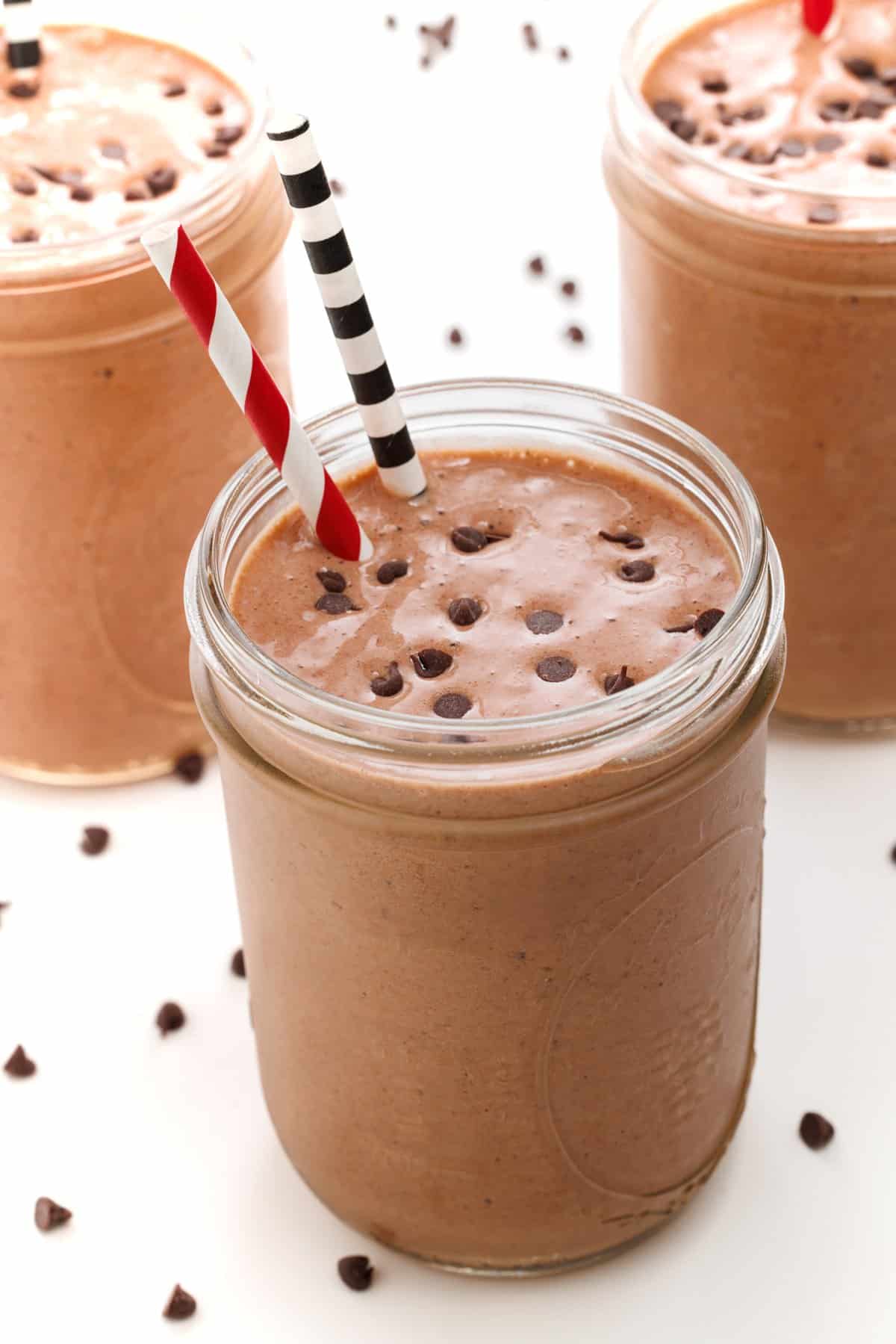 Chocolate strawberry protein smoothie in mason jar glasses.