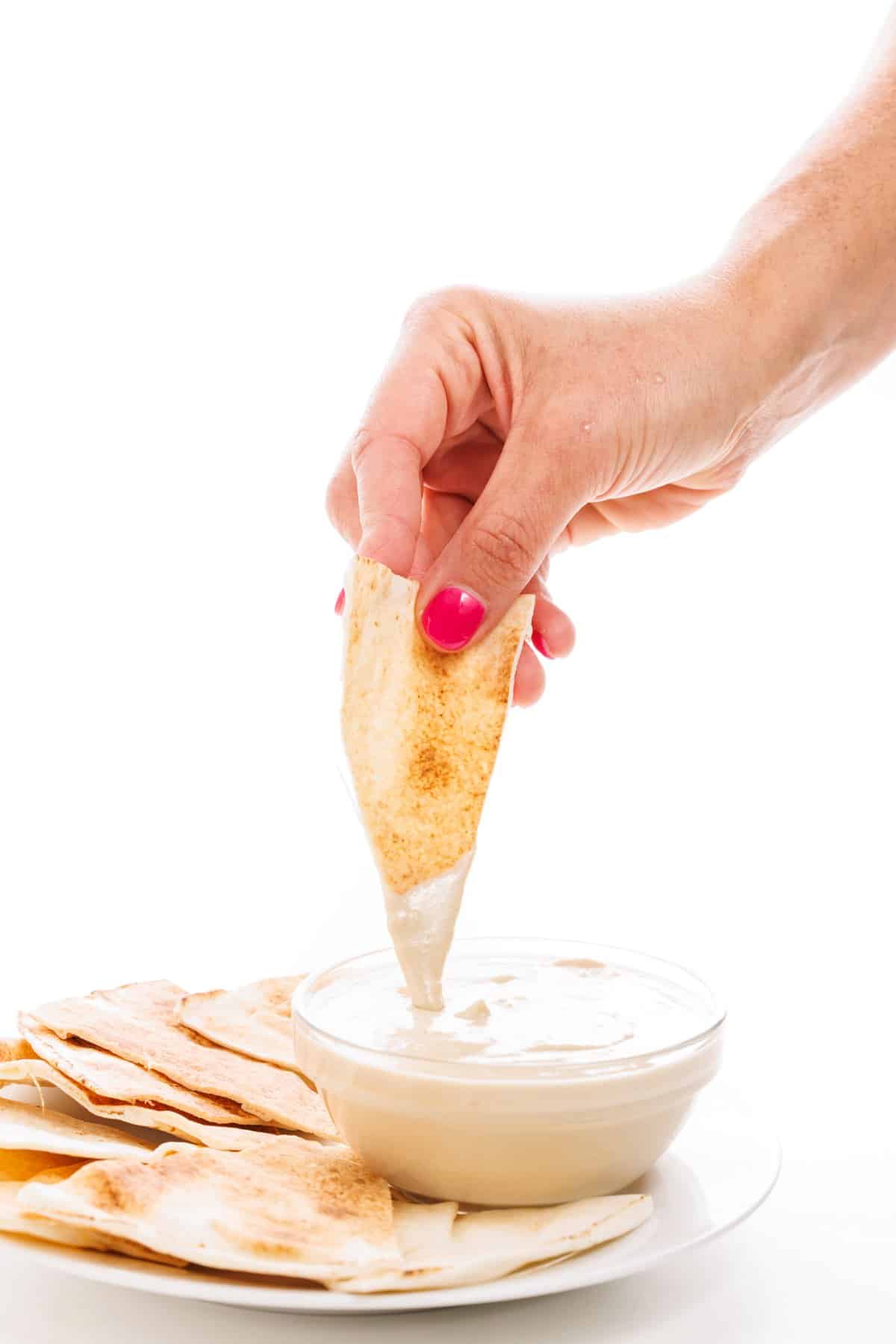 Dipping pita in tahini sauce.