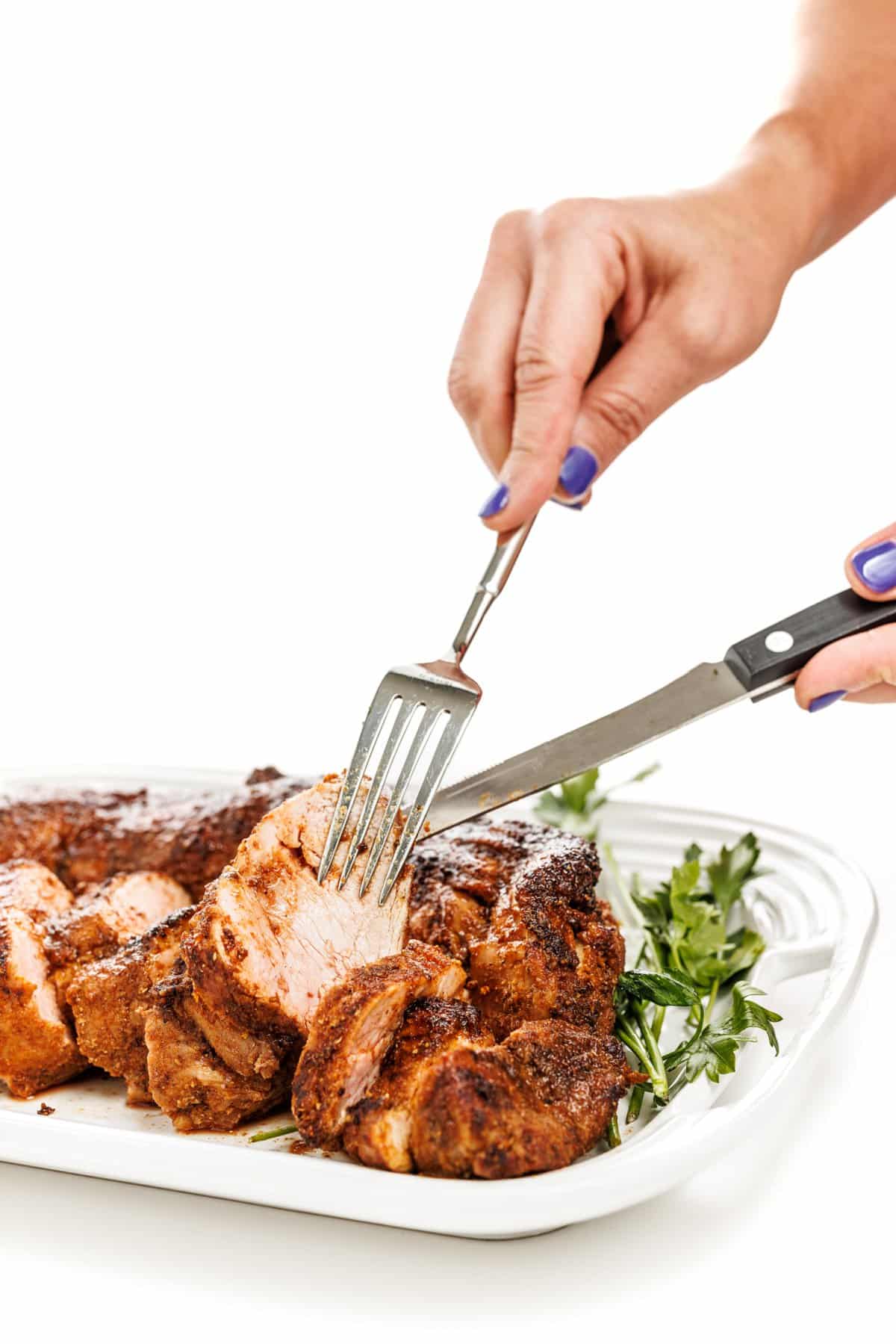 Cutting easy roasted spice-rubbed pork tenderloin.