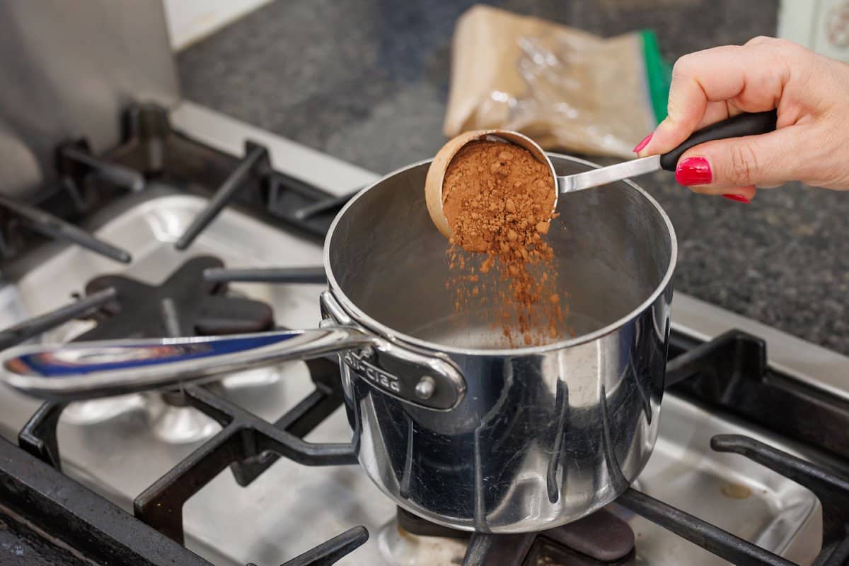 Adding cocoa powder to sauce pan.