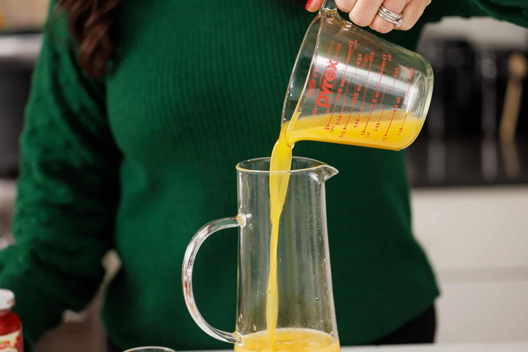 Pouring passion fruit juice into pitcher.