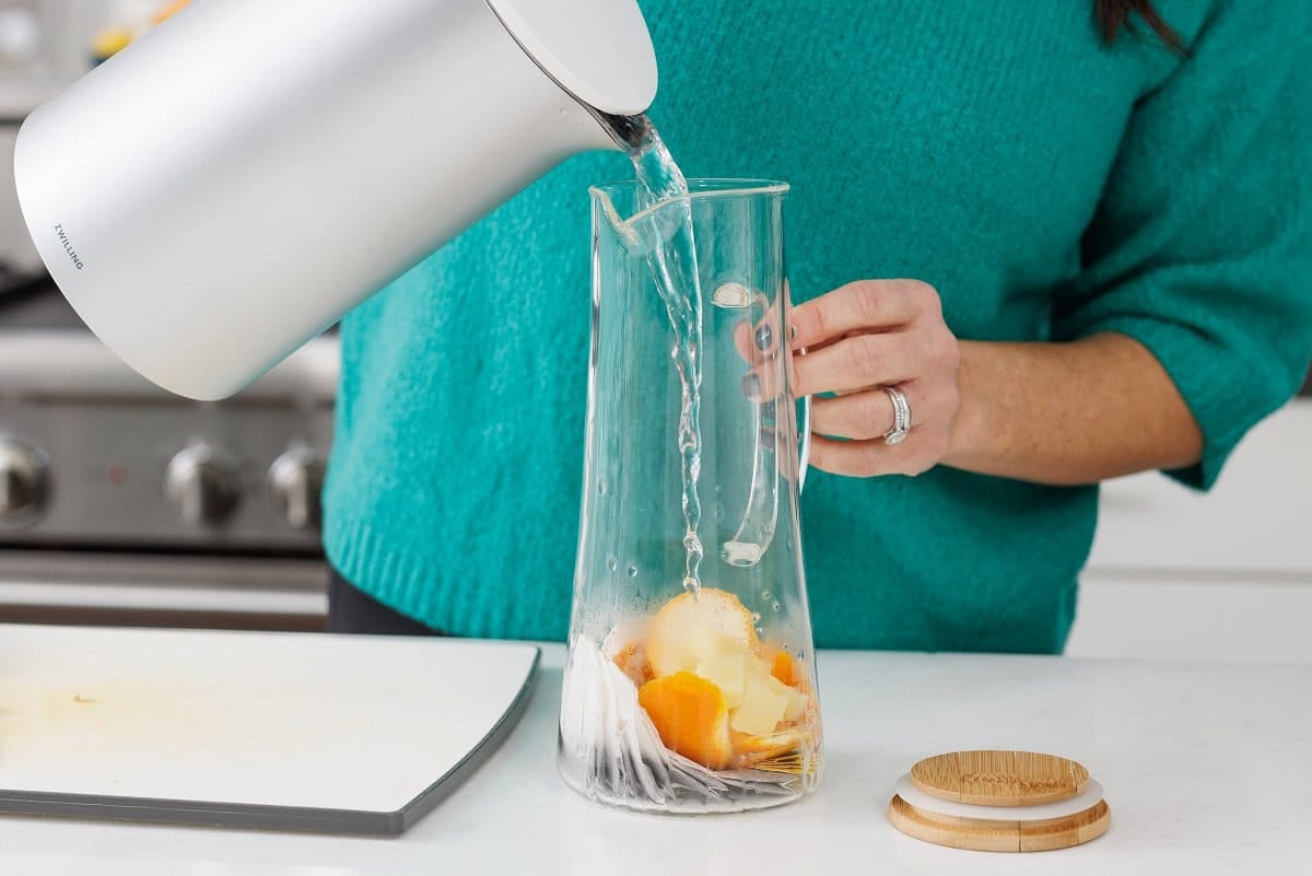 Pouring hot water into pitcher.
