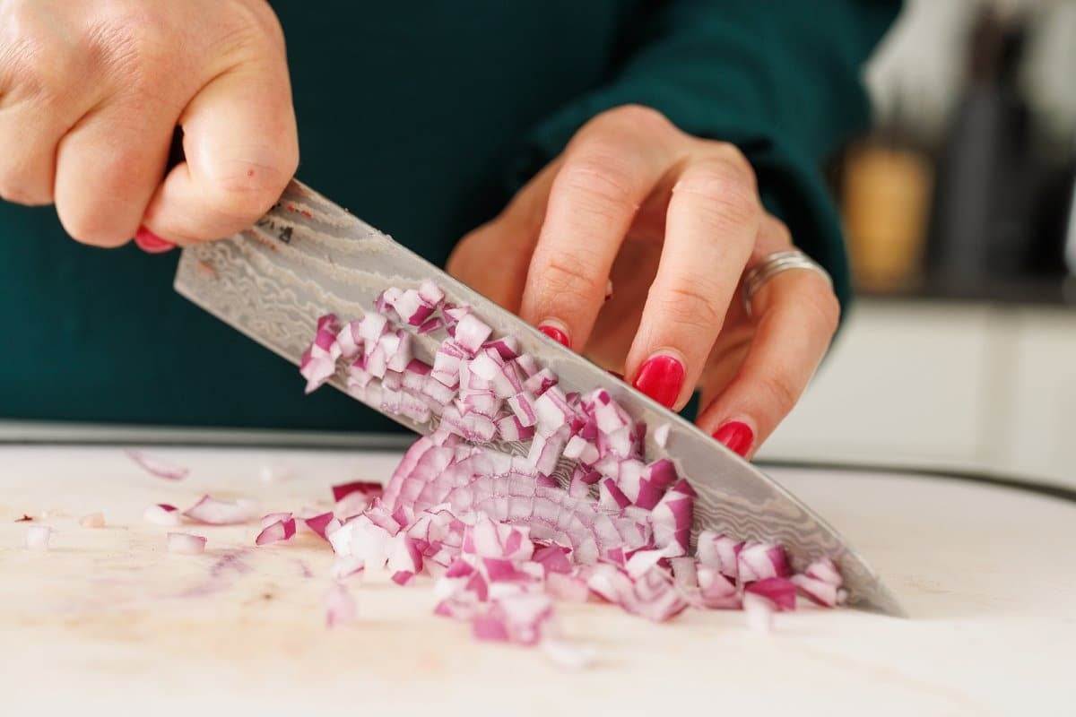 Lic mincing a red onion.