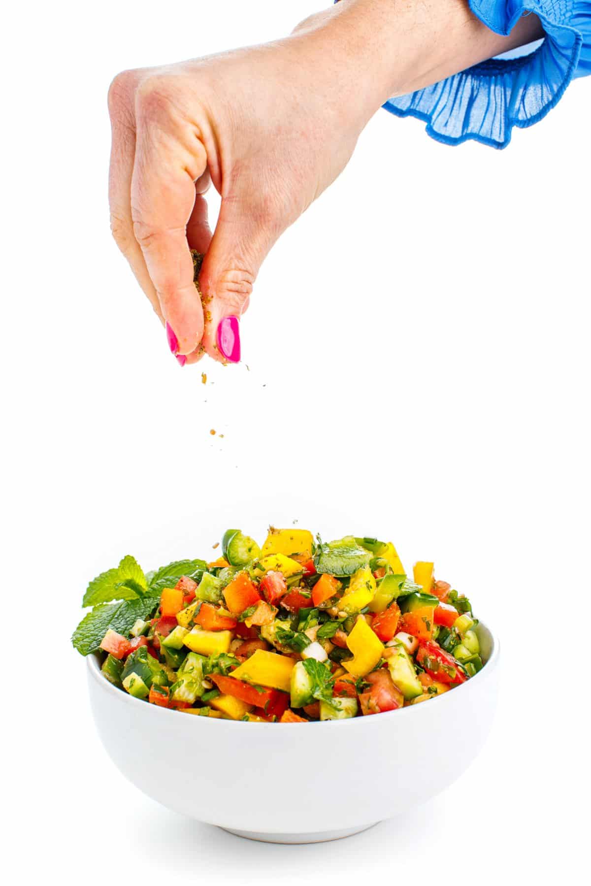 Garnishing Lebanese chopped salad.