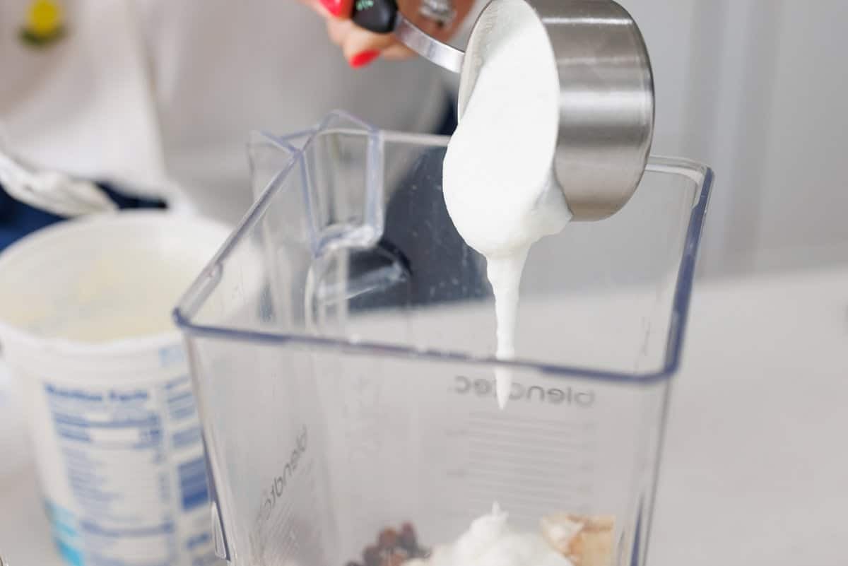 Adding yogurt to blender.