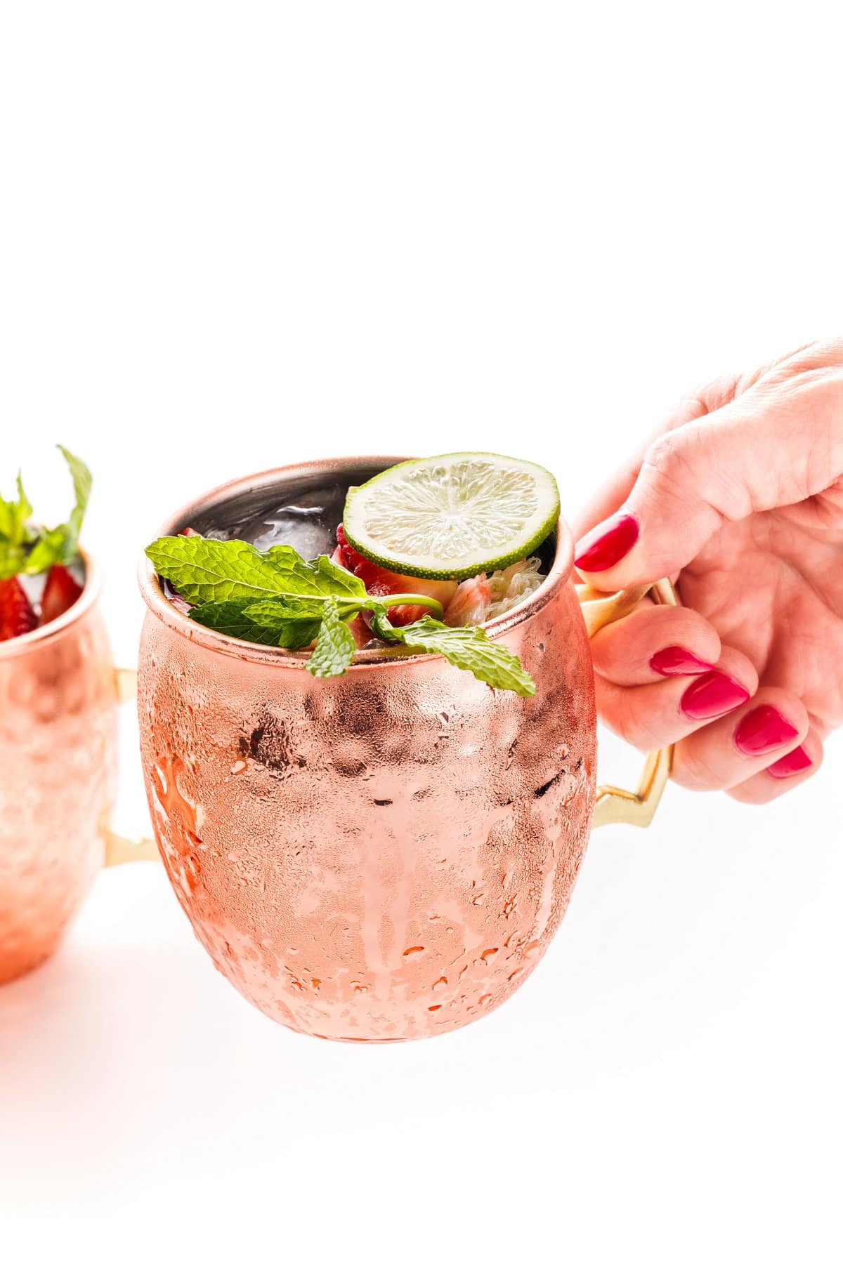 Holding a strawberry Moscow mule.