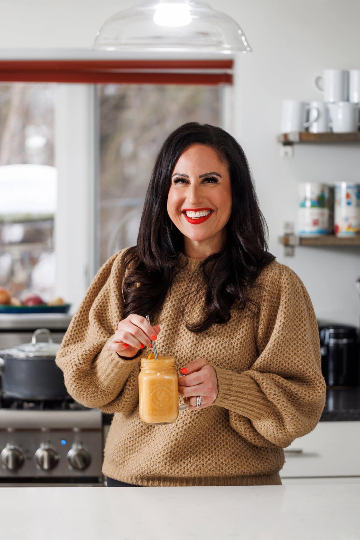 Liz drinking an orange ginger detox smoothie.