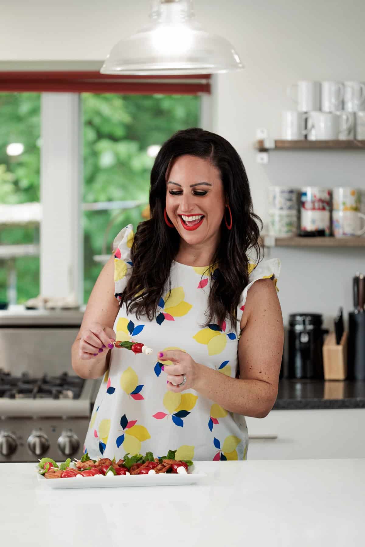 Liz eating smoked shrimp caprese skewers.