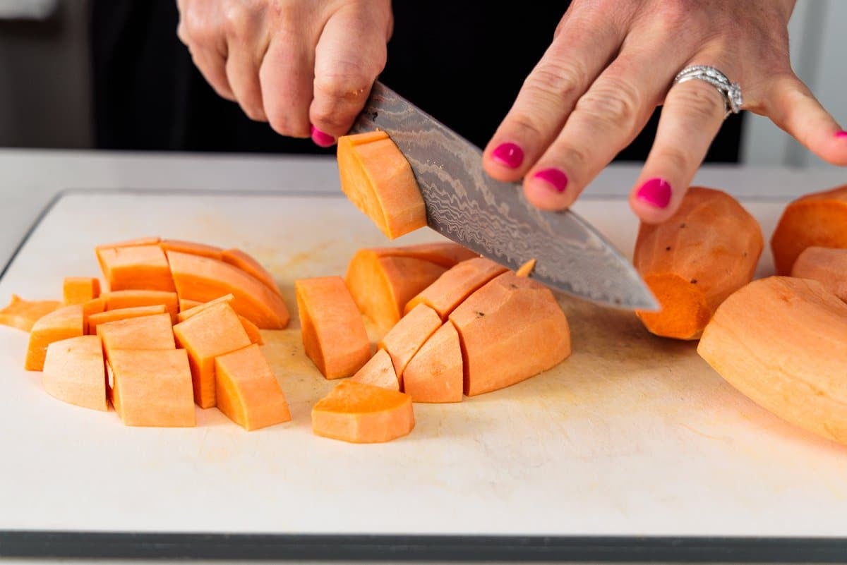 Liz cutting peeled sweet potatoes into cubes.