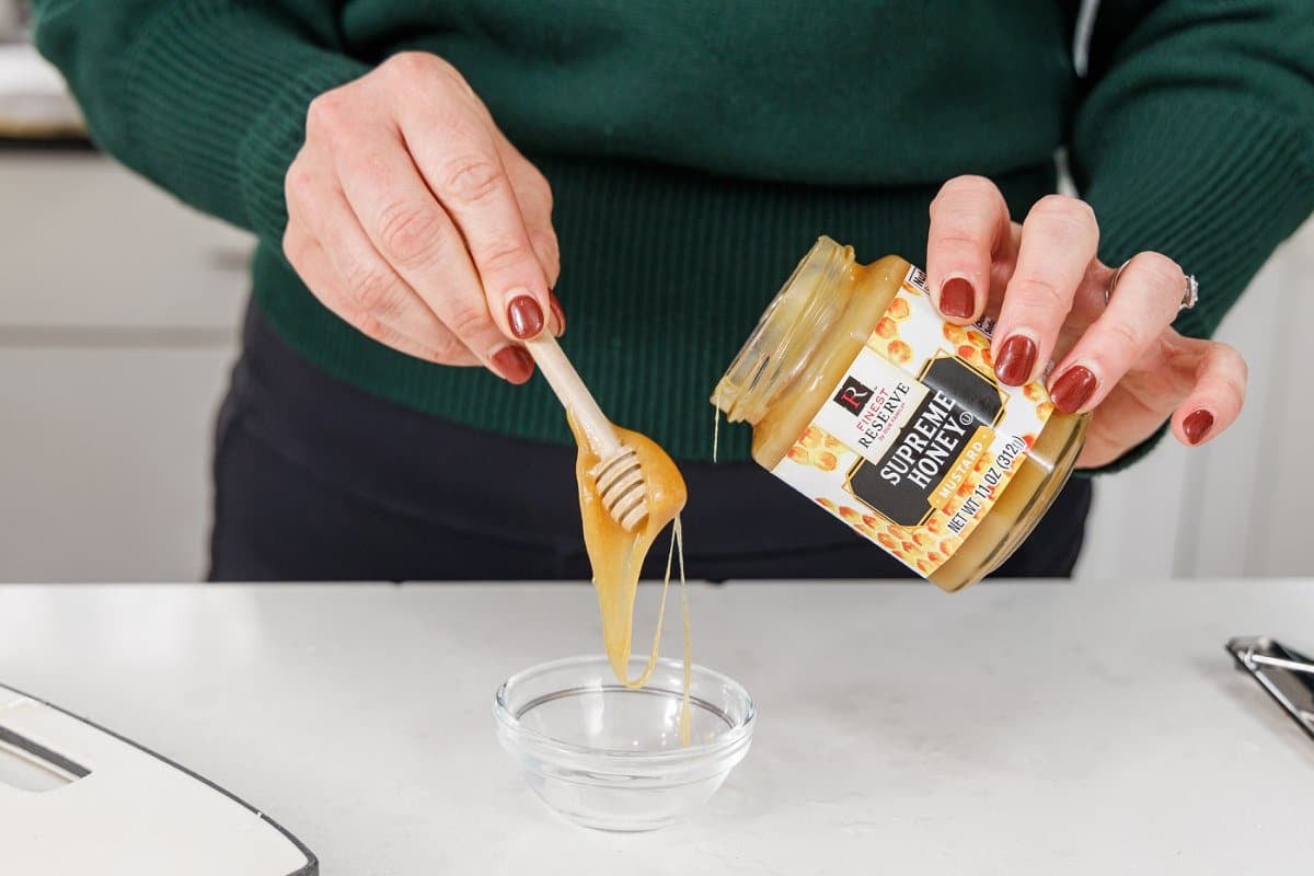 Adding honey mustard to a bowl.