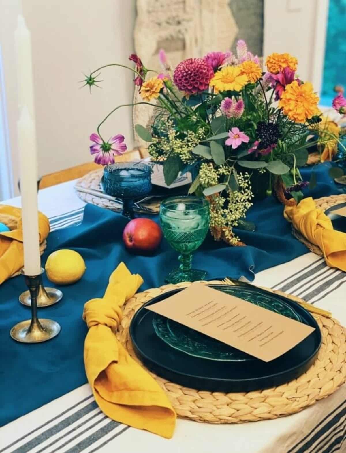 A table setting with fresh lemons and pomegranates as centerpieces.