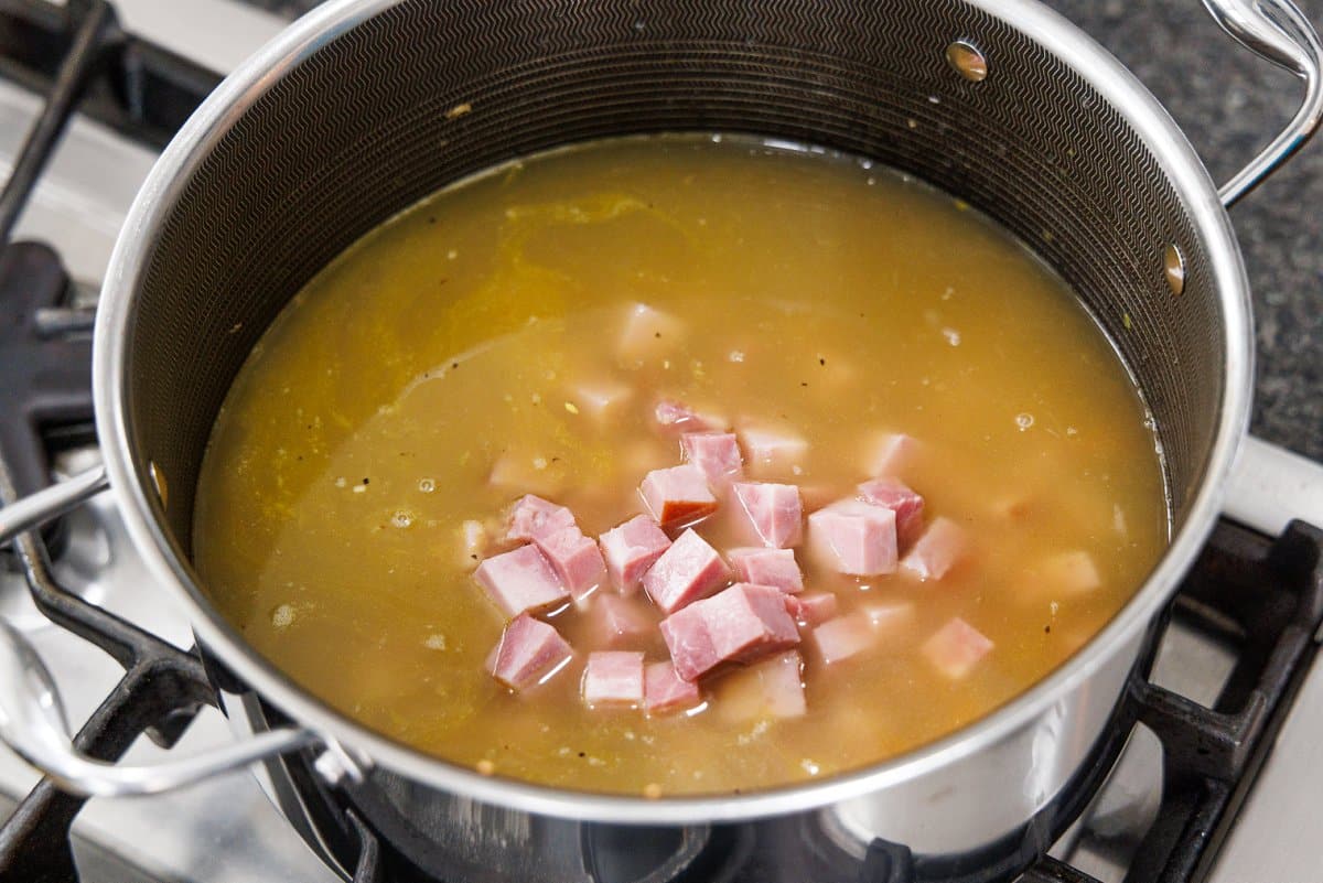 Ham and chicken broth added to a large soup pot.