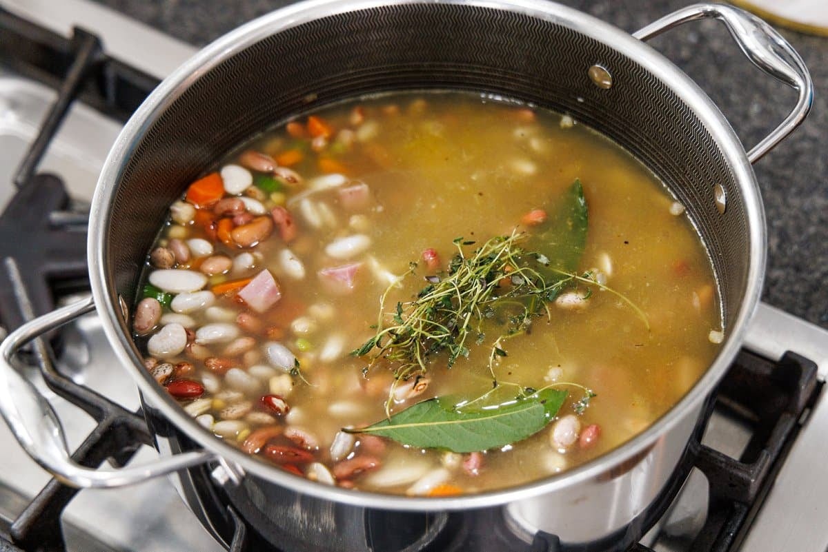 Fresh thyme and bay leaf added to 15 bean soup with ham.