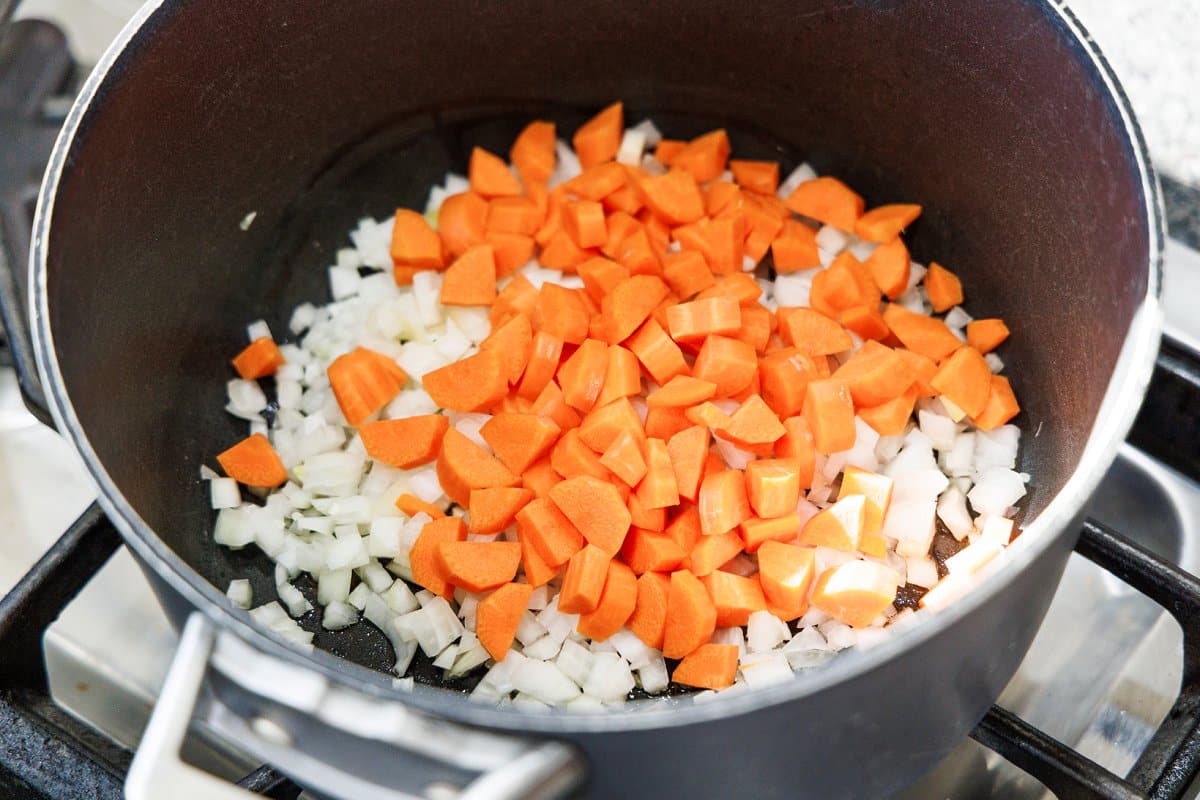Carrot added to diced onion in the bottom of the pot.