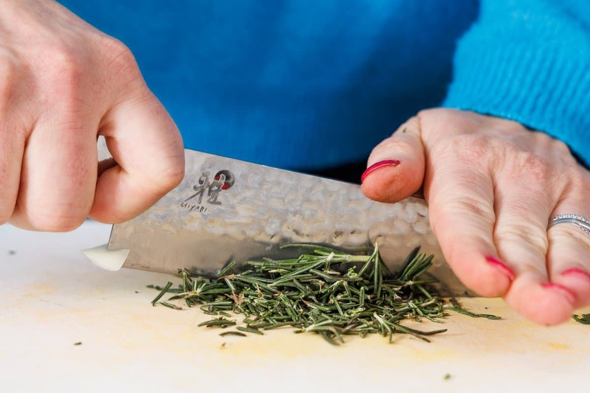 Mincing fresh rosemary with a very sharp knife.