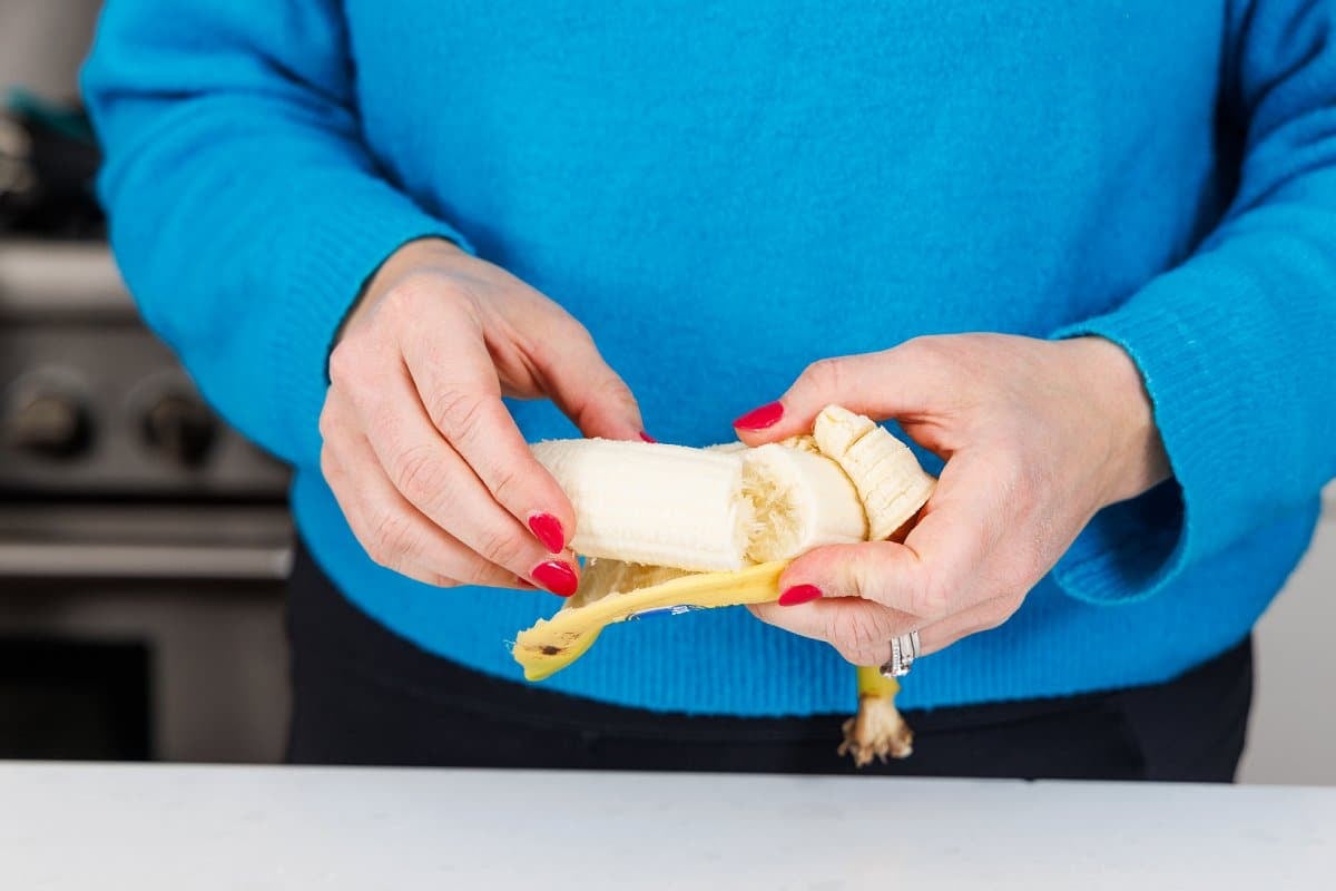 Peeling a banana and breaking it in half.