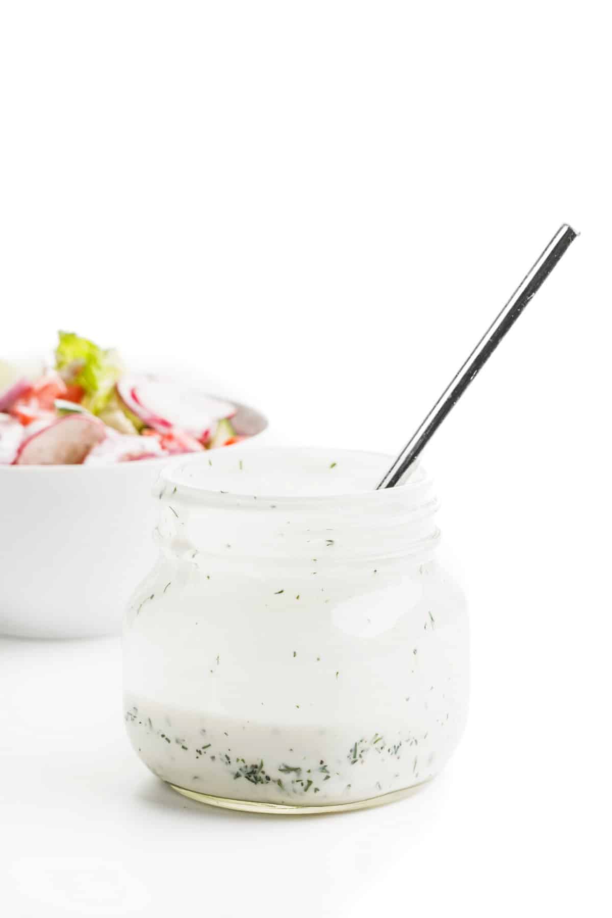 Jar of 5-ingredient dill ranch dressing with a spoon in it.