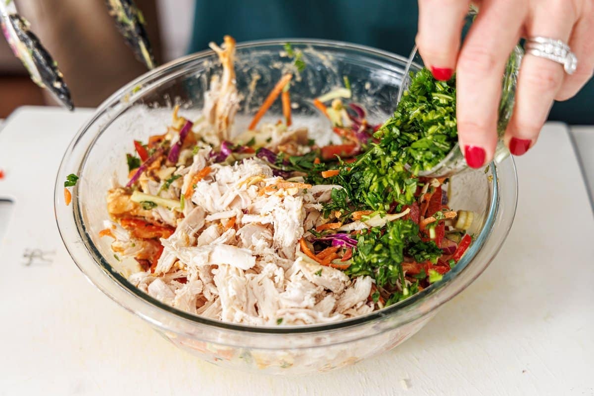 Adding freshly chopped herbs to salad.