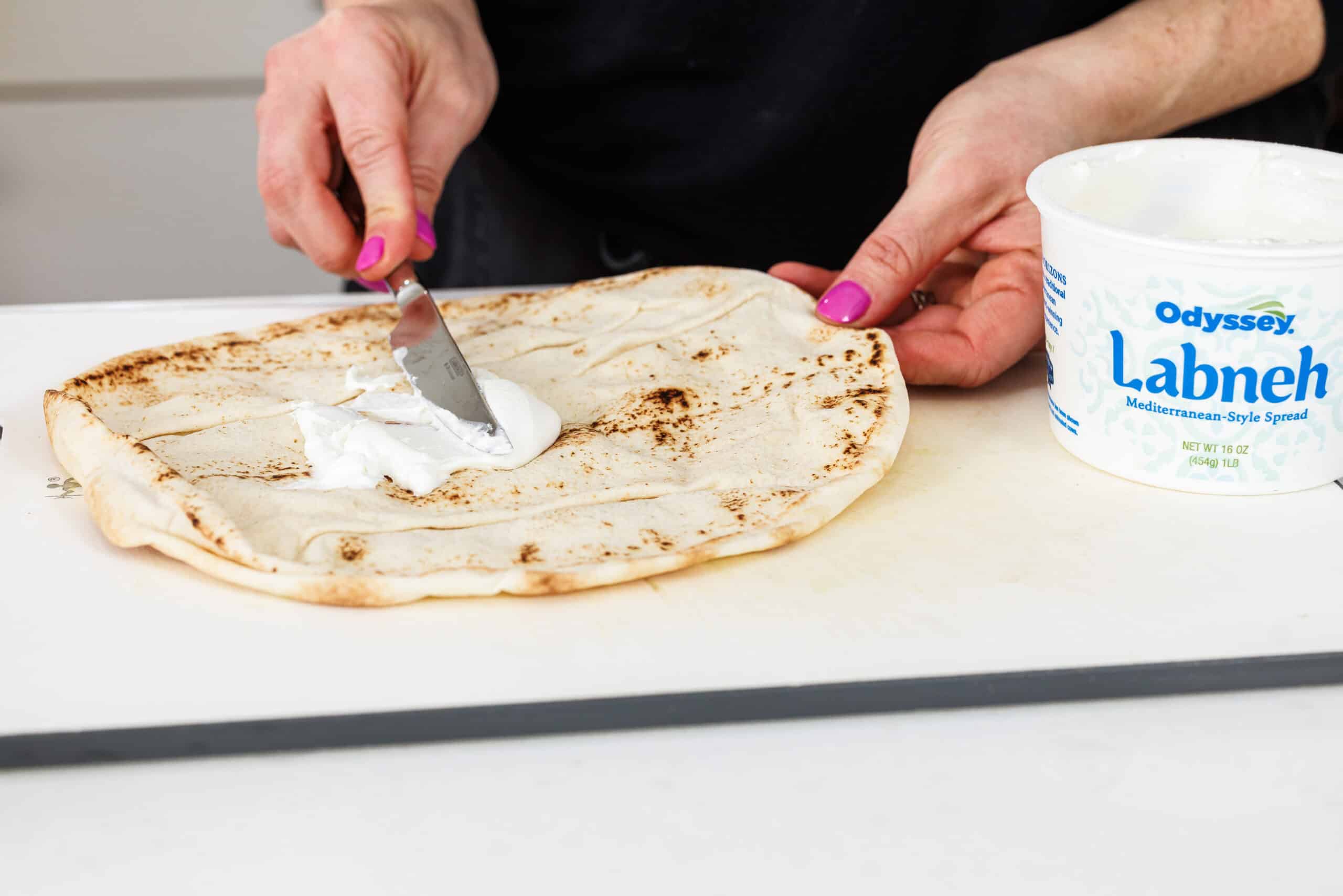 Spreading labneh on a pita.