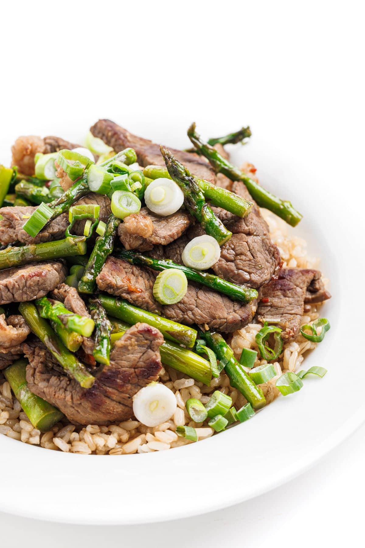 Ginger beef and asparagus stir-fry over rice and topped with freshly chopped chives.
