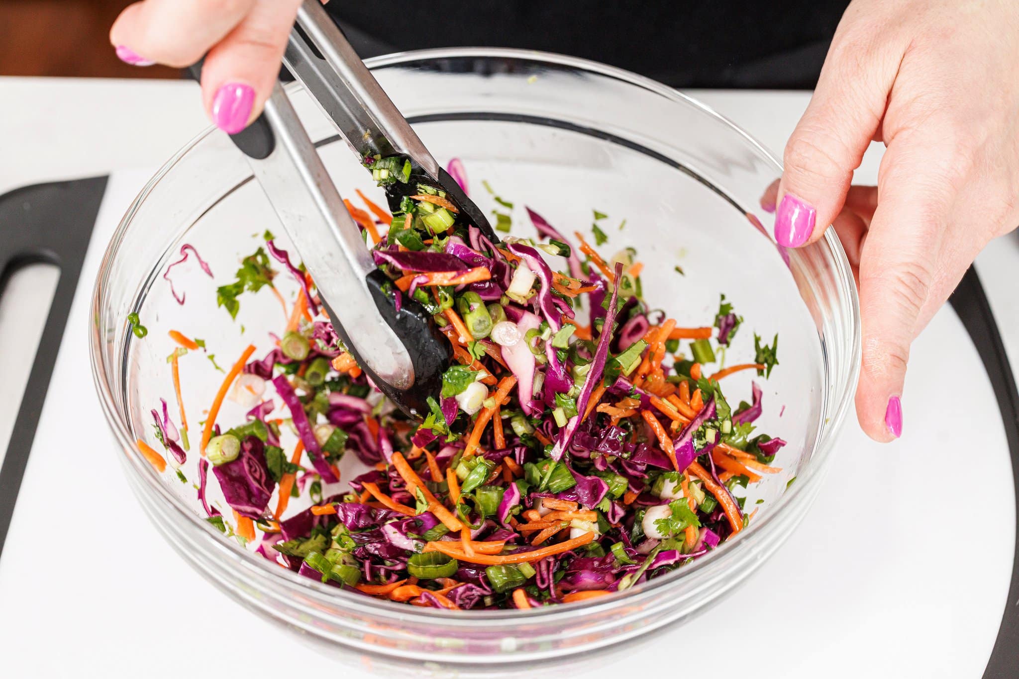 Tossing cabbage slaw.